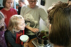 Einige Kinder und eine Frau bereiten palmölfreie Schokocreme zu.