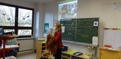 Unsere Umweltbildnerin steht mit einer Orang-Utan Handpuppe vor der Schulklasse.