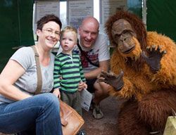 Eine Familie zusammen mit einem Vereinsmitglied im Orang-Utan-Kostüm.