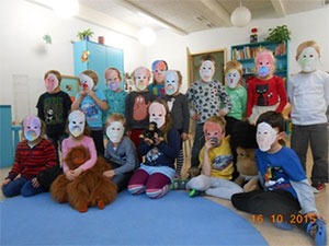 Ein Gruppenfoto mit Kindern, sie haben Papier-Orang-Utan-Masken auf.