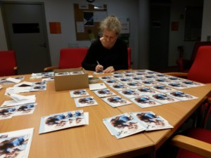 Julia Cissewski unterschreibt Autogrammkarten.