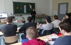 Einige Schulkinder hören sich einen Vortrag in einem Klassenzimmer an.