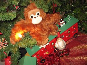Ein Plüsch Orang-Utans neben einem Weihnachtsbaum und einiger Weichnachtsdekoration.