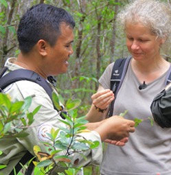 Julia Cissewski lässt sich von einem Mitarbeiter der Auffortsungsstation eine Pflanze zeigen.