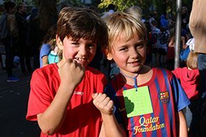 Zwei Kinder in Sportkleidung, sie schauen stolz in die Kamera. Ein Werbeplakat, das auf die Bedrohung des Leuser-Ökosystems durch Palmölplantagen und illegale Holzwirtschaft hinweist.