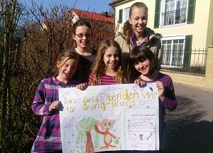 5 Mädchen halten einen selbstgemalten Spendenscheck in die Kamera.