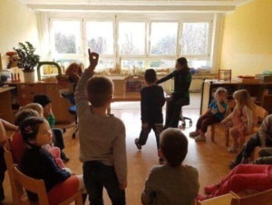 Die Kinder der KiTa sitzen in einem Stuhlkreis.