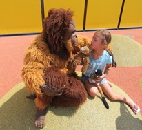 Unser Kostüm-Orang-Utan und ein Mädchen sitzen nebeneinander.