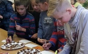 Schüler des Gymnasiums Engelsdorf stehen um einen Tisch und verkosten Schokocremes.