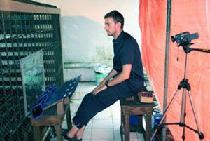 Dr. Daniel Haun in der Auffangstation beim Testen für eine Pilotstudie vor einem Orang-Utan-Gehege. Neben ihm steht eine Videokamera.