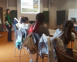 Der Teil der Klasse, die im Max-Planck-Institut sind, sitzen in einem Seminarraum und hören einer Präsentation zu.