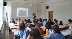 Die Klasse 10a bei dem Schulprojekt. Man sieht das volle Klassenzimmer und eine PowerPoint-Präsentation an der Tafel.