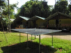 Die Solaranlage im Vordergrund und einige Hütten im Hintergrund.