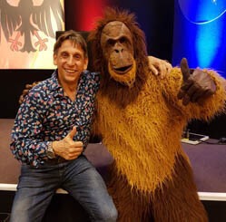 Thorsten Wolf steht lachend neben unserem lebensgroßem Orang-Utan-Kostüm.