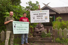 Sebastian Schorr und Togu Simorangkir mit einem symbolischen Scheck vor dem Umweltinformationszentrum.
