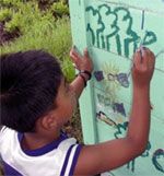 Ein Kind bemalt das Umweltbildungszentrum.