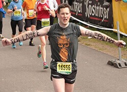 Ein Läufer beim Rennsteiglauf, auf seinen Armen steht mit schwarzer Farbe „Ich laufe ohne Palmöl“.