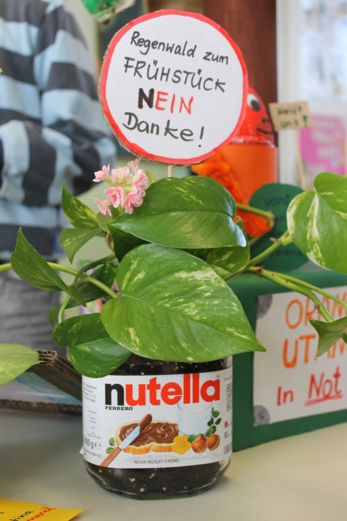 Ein Nutella-Glas, in dem ein Schild mit der Aufschrift „Regenwald zum Frühstück? Nein, danke.“ steht.