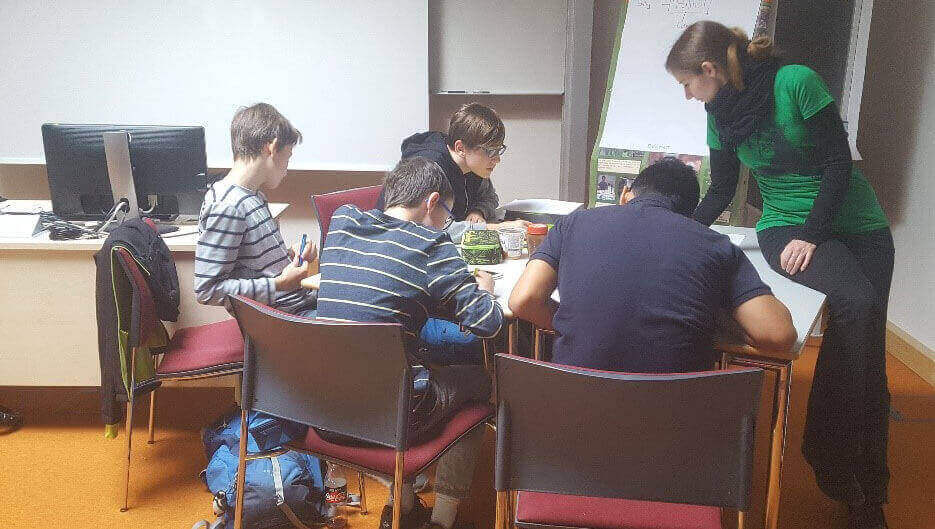 Vier Schüler sitzen um einen Tisch bei einer Gruppenarbeit.