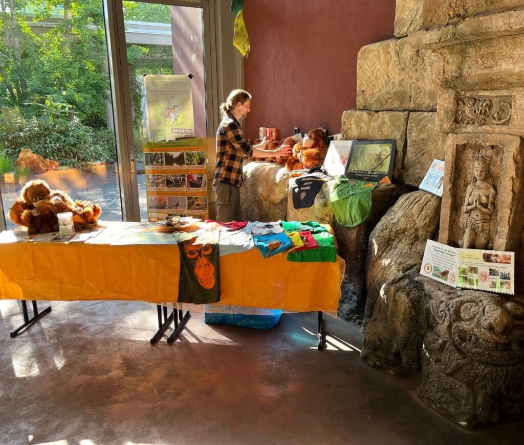 Ein Mitarbeiter am Stand des Vereins präsentiert Informationsmaterial, T-Shirts und Plüschtiere. Der dem Erlös aus dem Verkauf fließt in unsere Projekte.