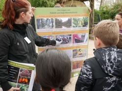 Süsann Jänig erklärt Grundschülern etwas auf einem Plakat.