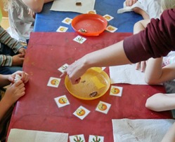 Die Vorschüler verkosten kleine Stücke Knäckebrot mit drei unterschiedlichen Schokoaufstrichen (mit und ohne Palmöl), die auf drei Tellern präsentiert werden. Jedes Kind kann eine Karte mit einer Ölpalme vergeben (zu dem Teller, in dem sie Palmöl vermuten) und ein Smiley zu dem Teller, dessen Schokoaufstrich am besten geschmeckt hat.