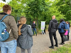 Die Umweltbildnerin zeigt den Teilnehmenden auf einem Plakat, wie der artenreiche Regenwald abgeholzt und durch artenarme Palmöl-Monokulturen ersetzt wird.