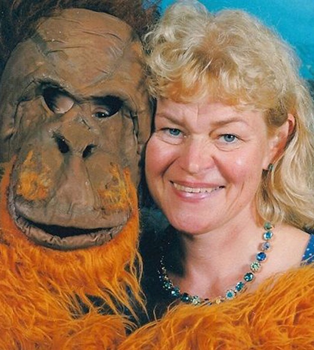 Portrait von Anna Riezschel, die einen Menschen im Orang-Utan-Kostüm umarmt.