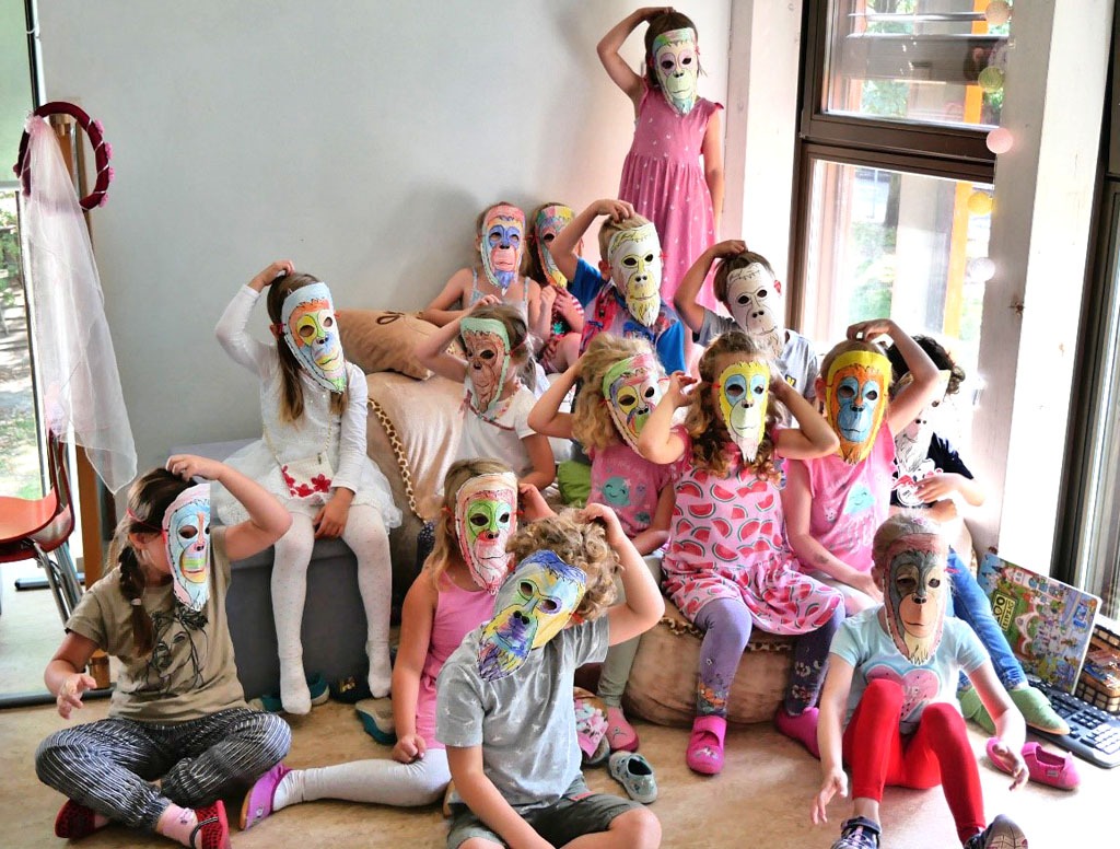 Die Vorschulgruppe in Affenpose mit selbst gebastelten Orang-Utan-Masken.