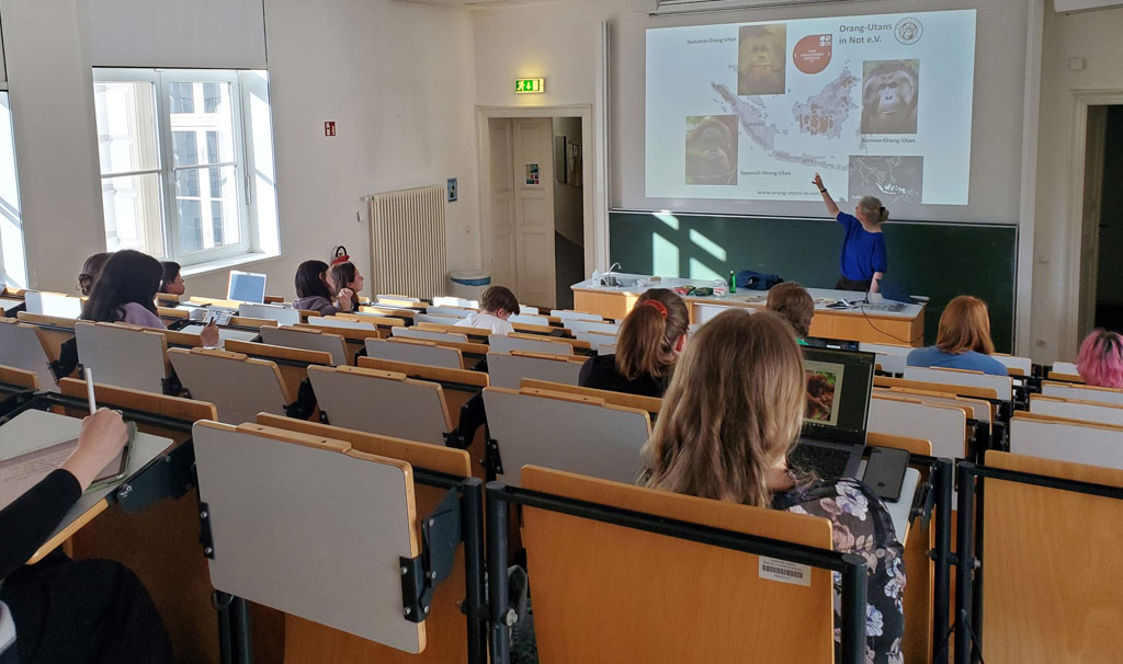 Julia Cissewski steht im Hörsaal und hält einen Vortrag vor einer Gruppe von Studenten.
