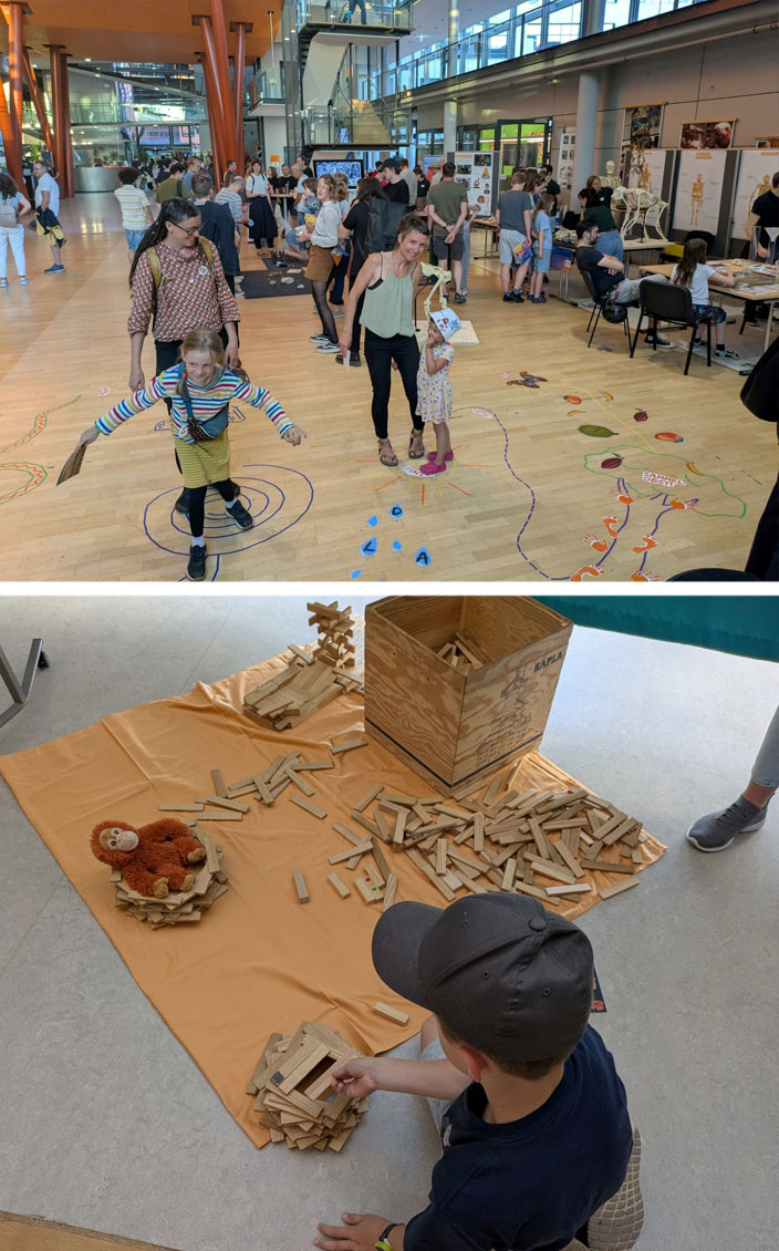 Bild oben: In der Eingangshalle des Max-Planck-Instituts für evolutionäre Anthropologie sind viele Besucher und verschiedene Stationen. Auf dem Boden ist ein farbiger Parcours aus Bildern und Klebestreifen aufgebracht, der von verschiedenen Personen absolviert wird. Bild unten: Ein Kind sitzt auf dem Boden. Darauf befindet sich eine Holzkiste mit Holzbausteinen, eine orangene Decke und ein bereits fertiggestelltes Nest, indem ein Orang-Utan-Plüschtier sitzt. Das Kind baut an einem weiteren Nest.