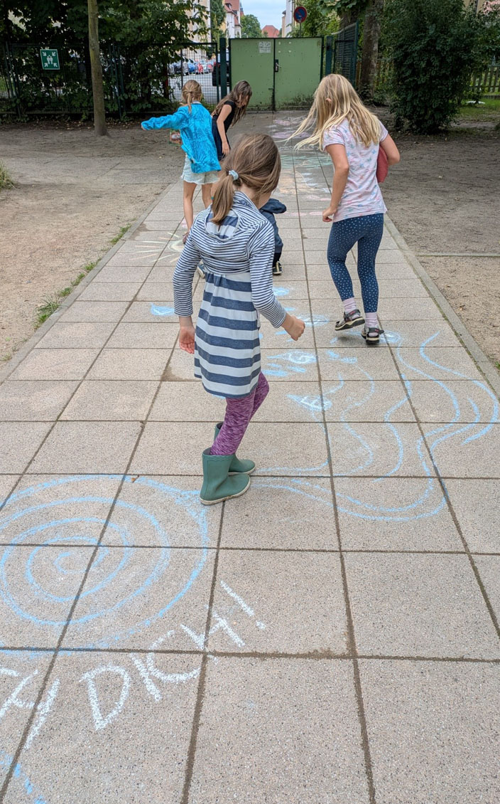 Vier Kinder bewegen sich durch den Kreideparcours.