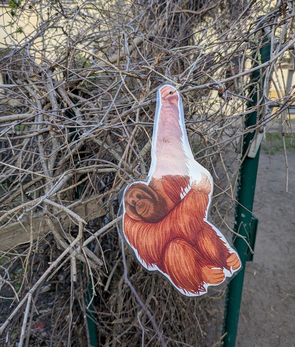 In einem Busch hängt ein Orang-Utan-Bild.