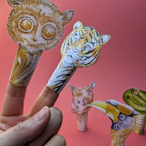 Foto selbstgebastelter Tier-Fingerpuppen vor einem roten Hintergrund. Folgende fünf Tier-Fingerpuppen sind abgebildet: Koboldmaki-, Tiger-, Nashorn-, Schlange- und Nashornvogel-Fingerpuppe.