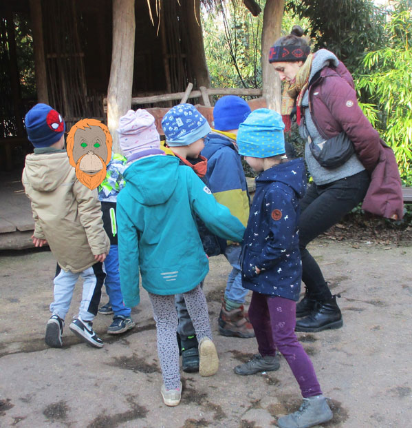 Mehrere Kinder und die Umweltbildnerin spielen ein Bewegungsspiel im Freien.