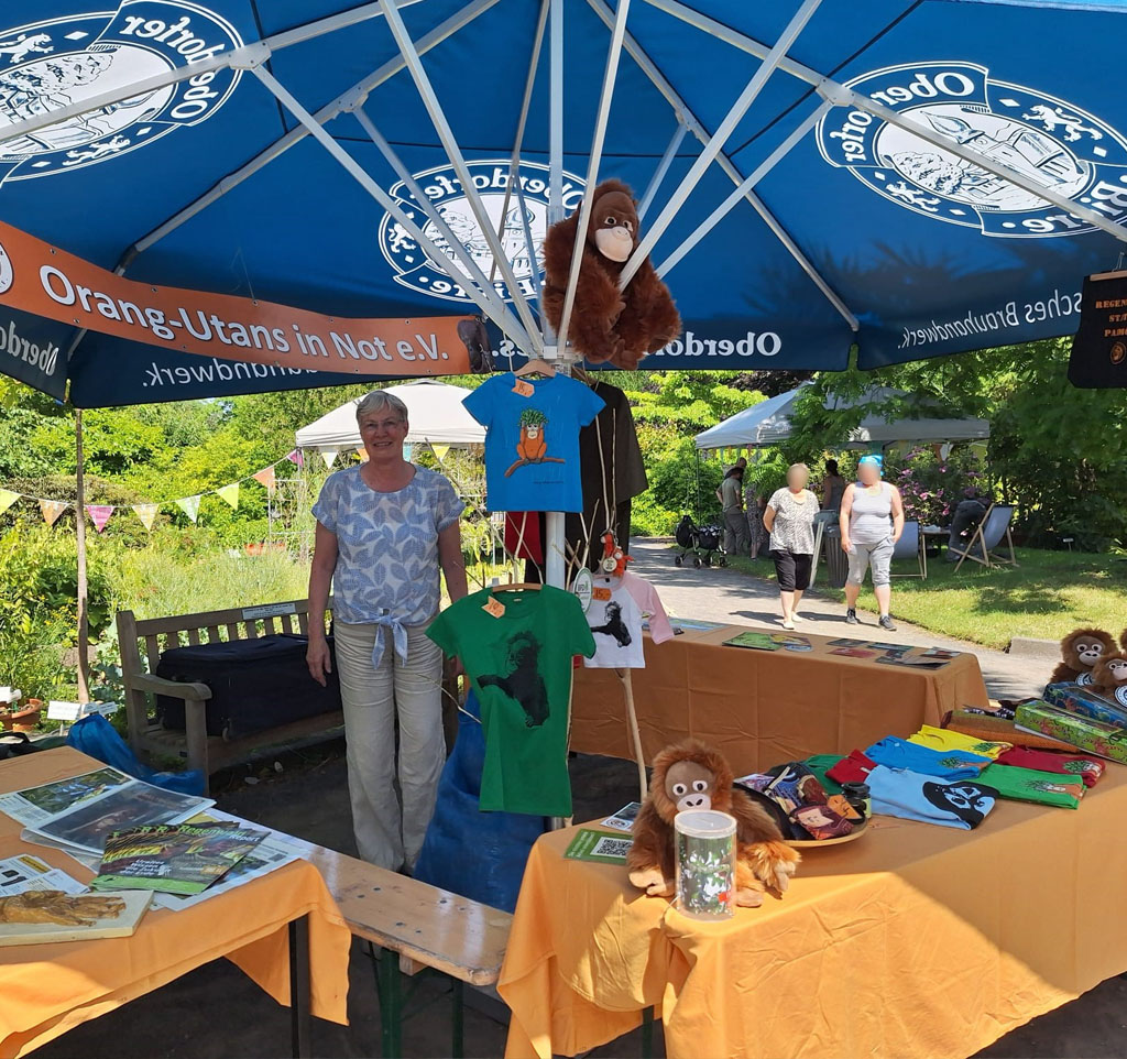 Unser Infostand auf der Botanika. Am Stand liegen verschiedene Verkausartikel, Flyer und Aktionsmaterialien für Kinder aus.