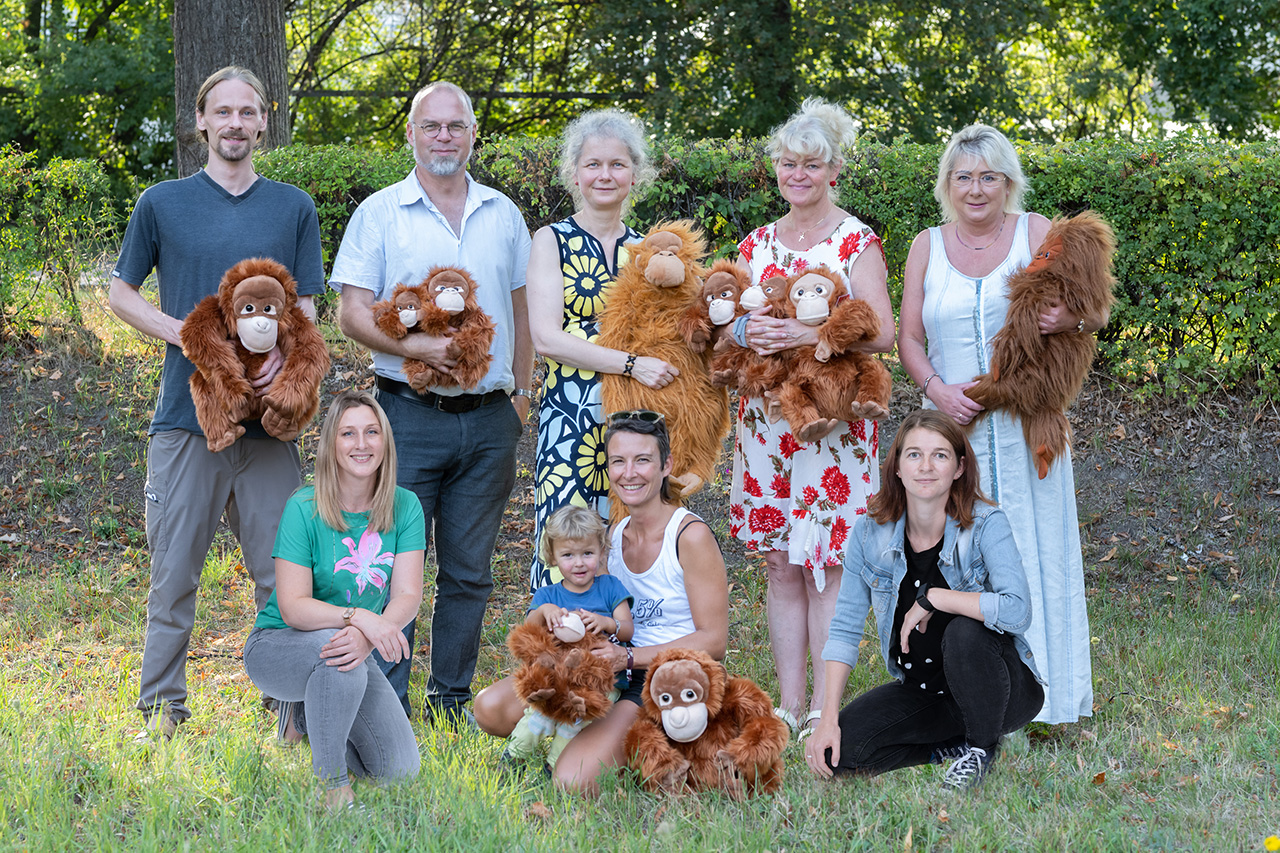 A group photo with eight members of the organization. Some of the members are holding a plush orangutan.