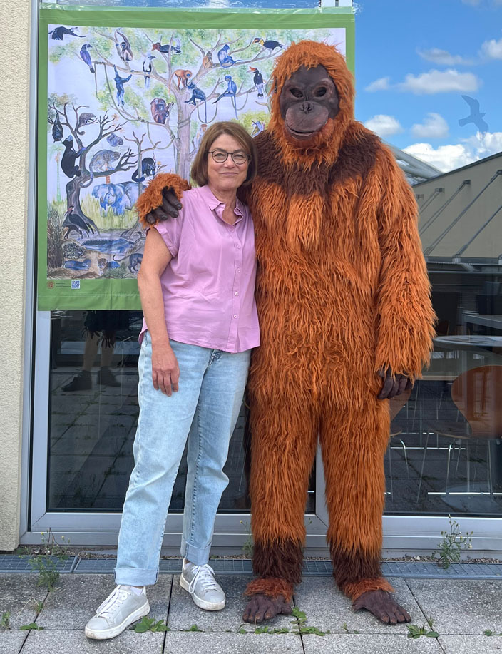 Ein Vereinsmitglied posiert mit einem Menscehn in einem Orang-Utan-Kostüm vor der Kamera.