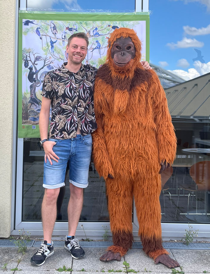 Ein Vereinsmitglied posiert mit einem Menscehn in einem Orang-Utan-Kostüm vor der Kamera.