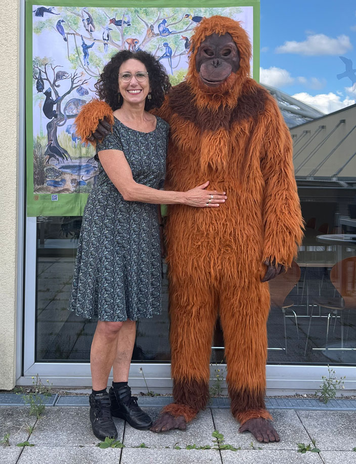 Ein Vereinsmitglied posiert mit einem Menscehn in einem Orang-Utan-Kostüm vor der Kamera.
