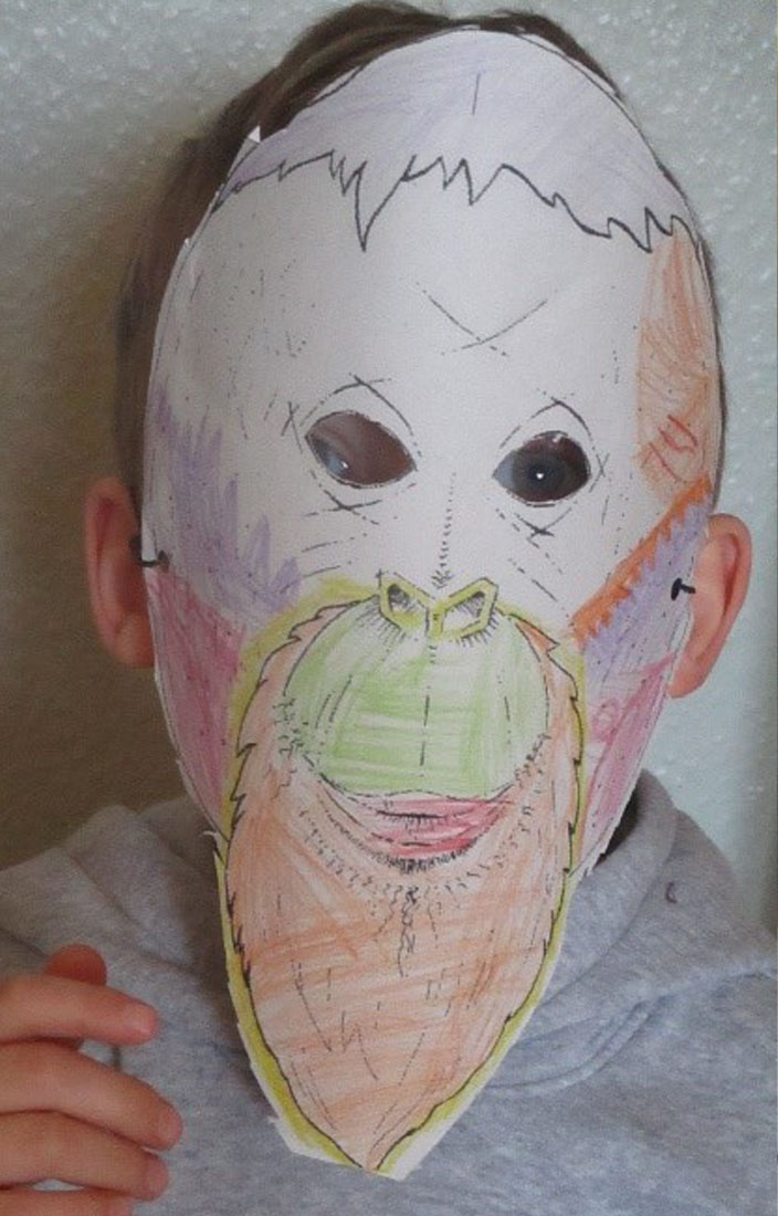 Ein Kind trägt eine bunte Orang-Utan-Maske