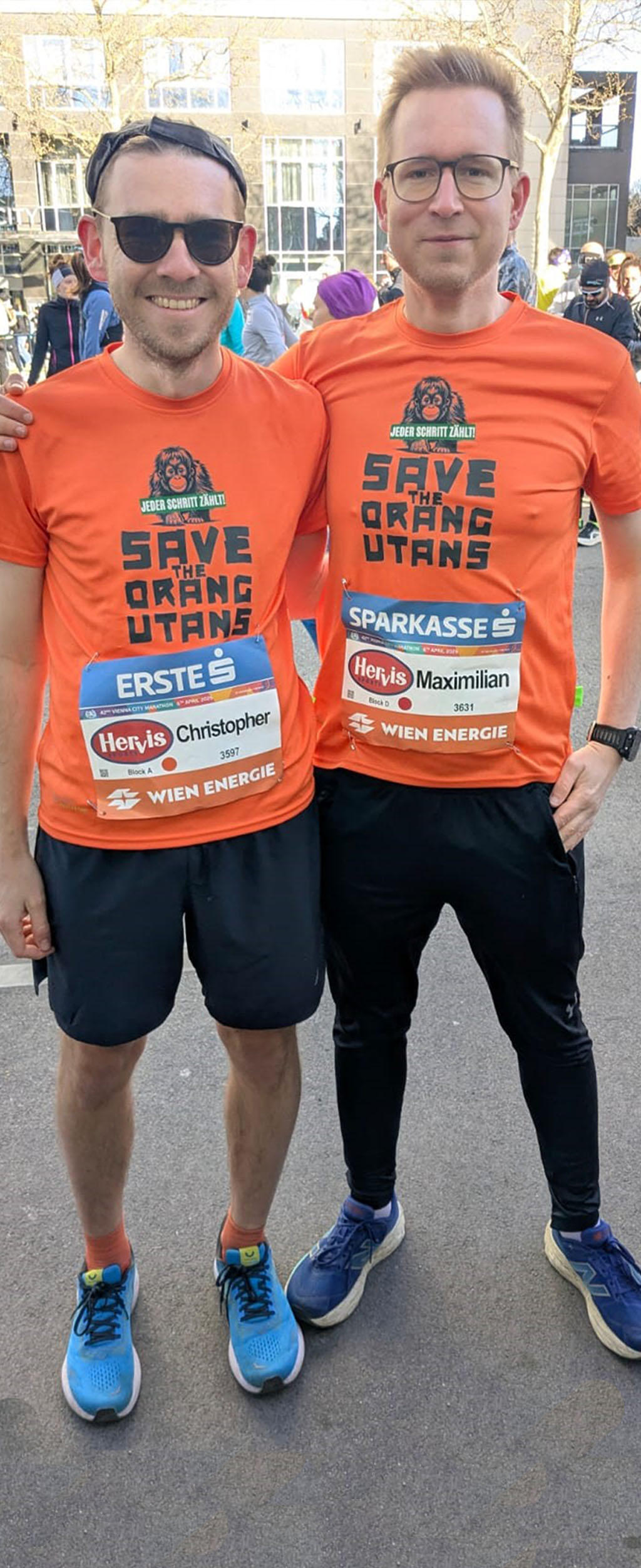 Maximilian und Chris vor dem Marathon: Beide tragen ein orangenes T-Shirt mit dem Aufdruck "Save the Orangutans" und einem Orang-Utan-Motiv.