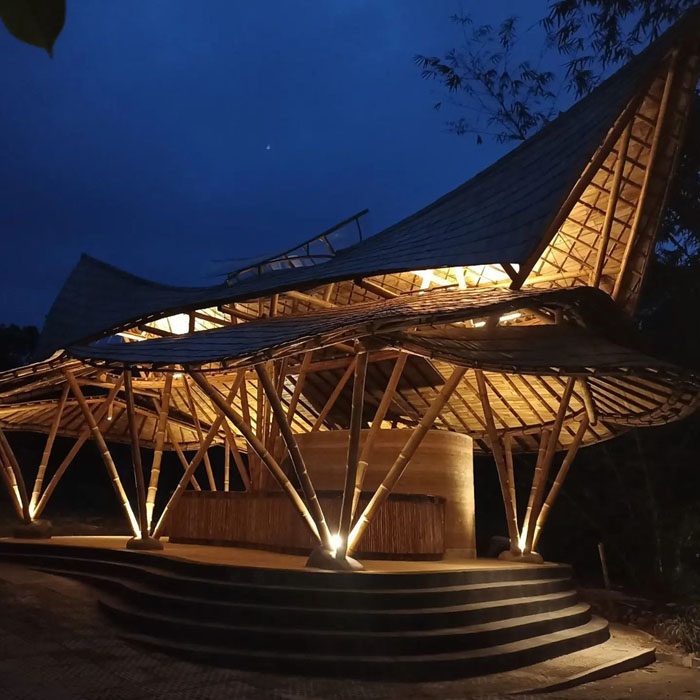 A building made of bamboo illuminated at night.