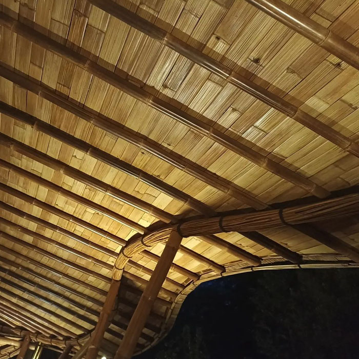 View from below of a curved bamboo roof.
