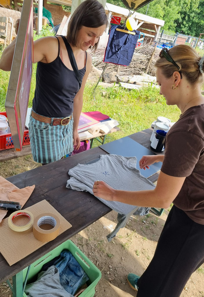 Eine Besucherin an unserem Stand bestaunt ihr eigens bedrucktes T-Shirt.