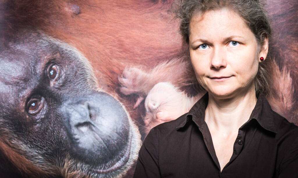 Portrait von Julia Cissewski vor einem Orang-Utan-Bild.